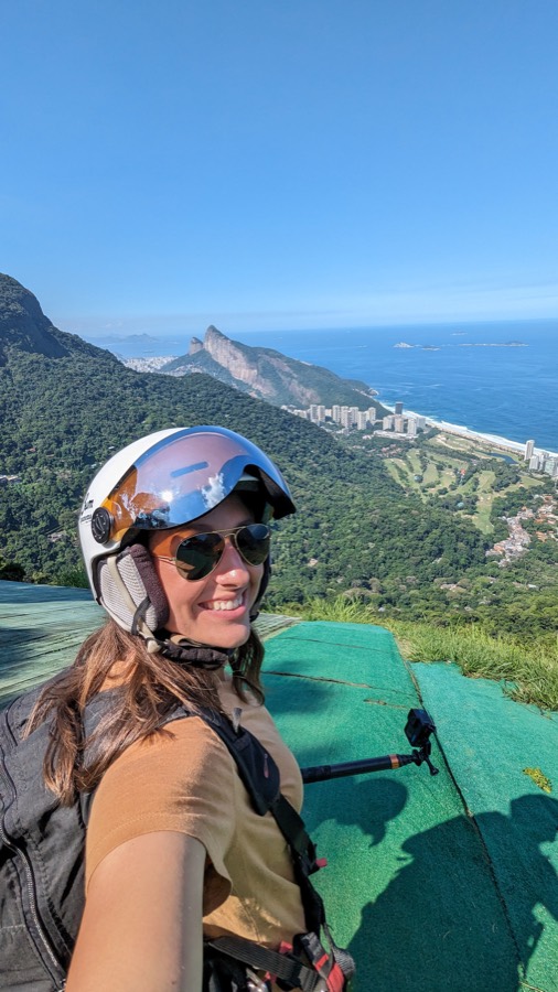 Alexandra in a paragliding helmet above São Conrado beach
